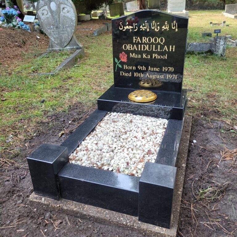 Black granite headstone and kerb set with gold lettering and white chippings