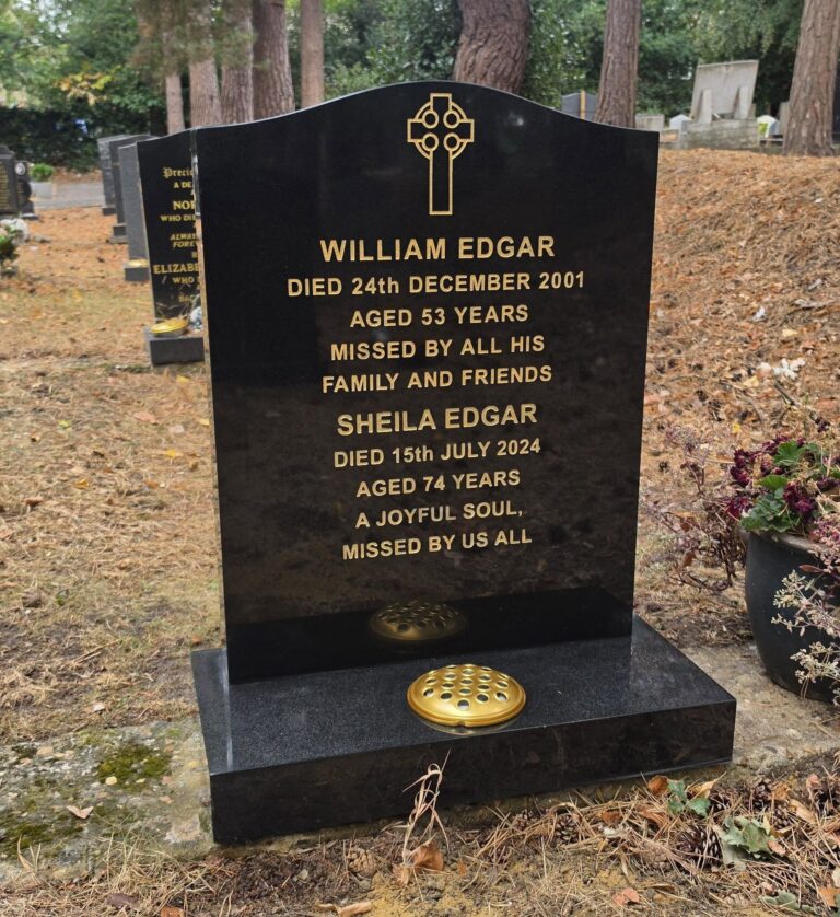 Black granite headstone with gold lettering and vases