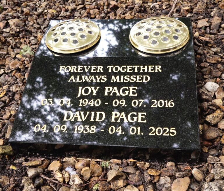 Black granite memorial tablet with gold lettering and vases
