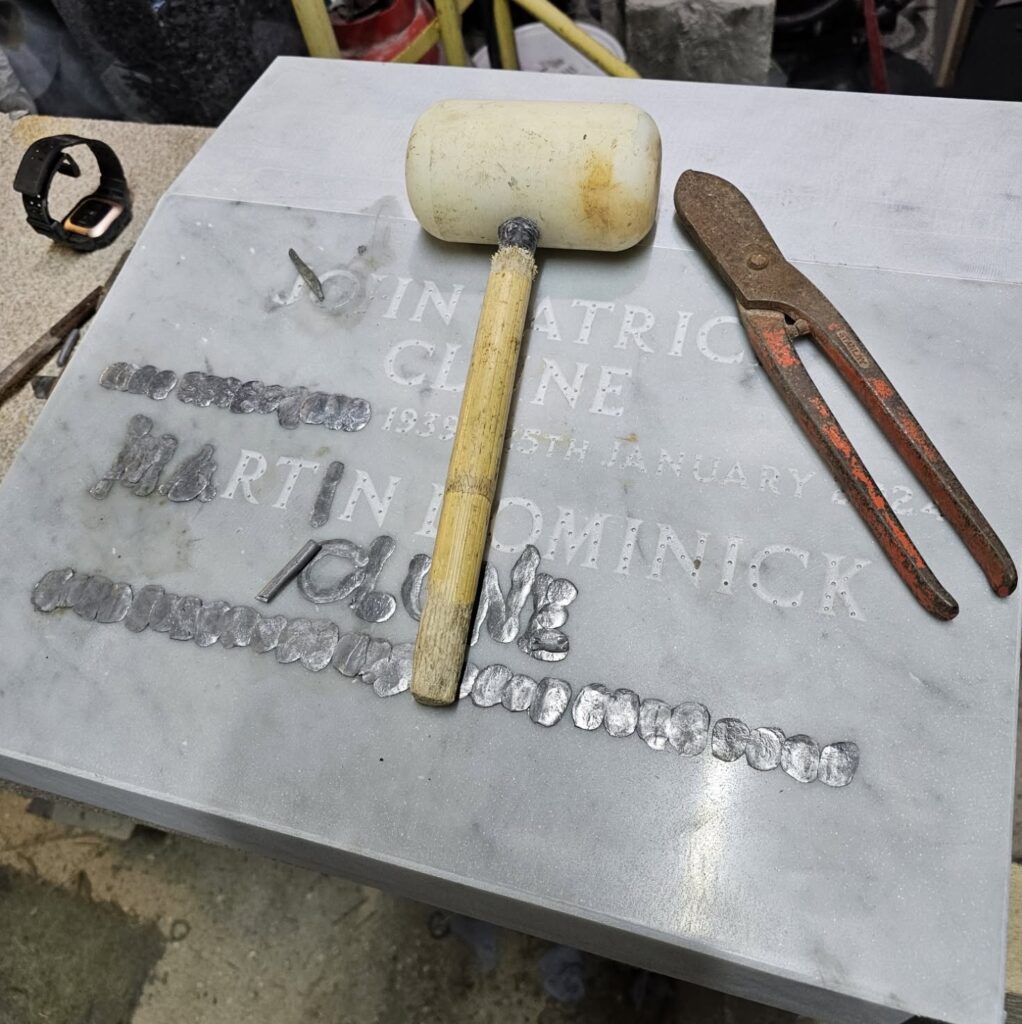 Mallet and chisel used to hand-cut lettering in stone