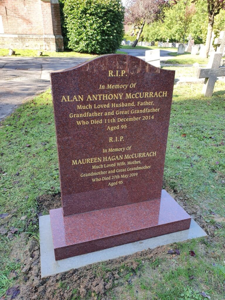 Red granite headstone with gold lettering